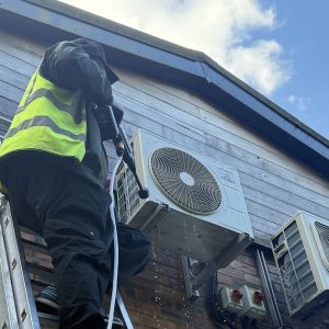 Engineer servicing outdoor air conditioning unit during annual maintenance