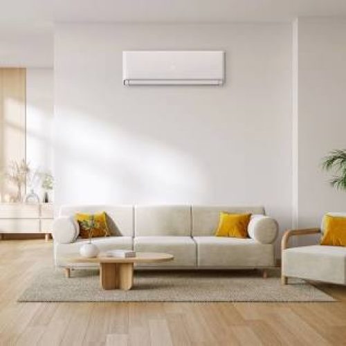 Sleek wall-mounted split air conditioner mounted above a sofa in a modern UK home interior