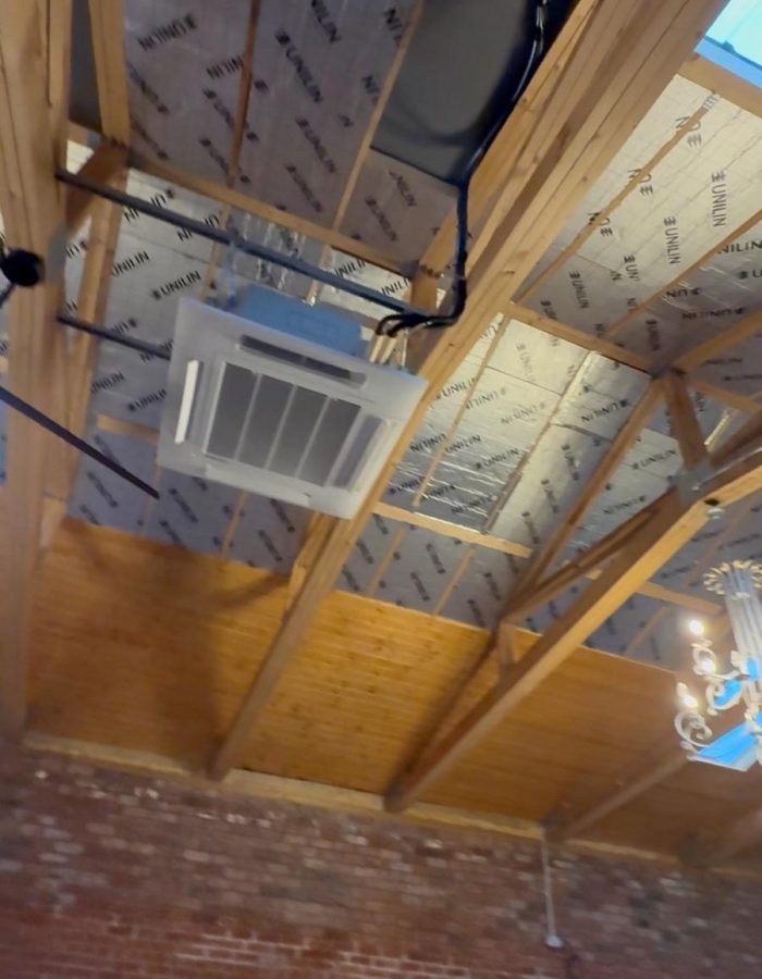 Ceiling cassette air conditioning system installed in a commercial property in Wales for even airflow and energy efficiency.